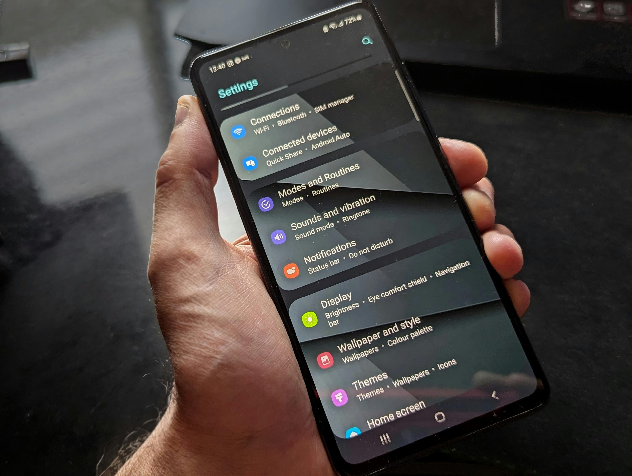 Cầm điện thoại và mở mục Settings - minh hoạ thao tác chỉnh tên và tuỳ chọn nhóm