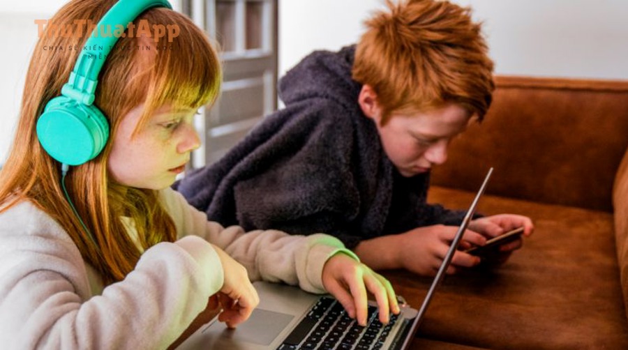 two kids using tablet and phone